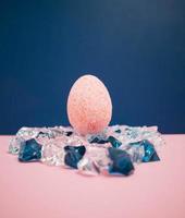 roze Pasen ei tegen donker blauw achtergrond houdende Aan blauw en transnapert Kristallen foto