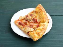 plak van pizza met vlees topping foto