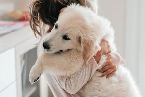 kind meisje Speel knuffelen hond puppy gouden retriever, huisdier behandeling en canisterapie voor volwassenen en kinderen. dier canis bijgestaan therapie. kinderen emotie mentaal Gezondheid vrienden liefde strak knuffelen foto