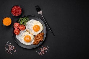 heerlijk hartelijk ontbijt bestaande van twee gebakken eieren, ingeblikt linzen en microgreens foto