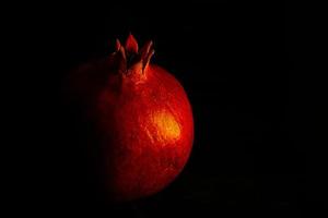 rijp granaatappel fruit Aan een zwart achtergrond dichtbij omhoog foto