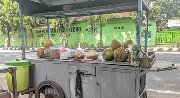 kraampjes van straat verkoper verkoop jong kokosnoot ijs foto