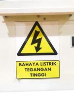 Gevaar hoog Spanning teken met tekst geïsoleerd geel insigne in Indonesisch bahaya listrik tegangaan tinggi foto