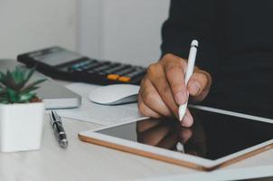 persoon die een tablet aan een bureau gebruikt foto