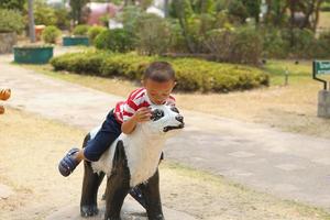 jongen spelen in de speelplaats in de park foto