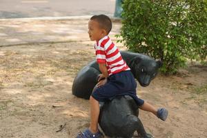 jongen spelen in de speelplaats in de park foto