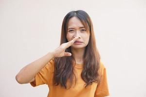 Aziatisch vrouw aan het bedekken haar neus- met haar handen ten gevolge naar geur foto