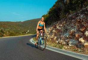 vrouw fietser rijden een fiets Aan een berg weg foto