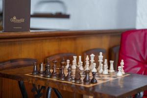 houten wit en bruin schaak stukken geregeld Aan schaakbord in alpine hotel foto