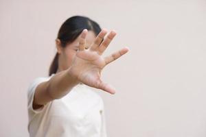 Aziatisch vrouw gebruik makend van haar handen naar beschermen tegen inkomend gevaren foto