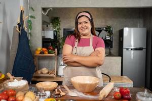 portret van zwaarlijvig vrouw Koken pizza in de keuken, rauw pizza in de handen van een huisvrouw. eigengemaakt pizza Koken in de keuken Bij huis. aan het leren hoe naar maken lekker pizza avondeten lunch foto