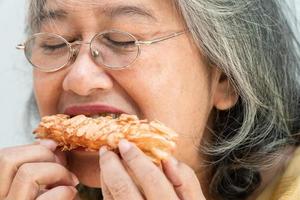 gelukkige Aziatische senior vrouwen genieten van het eten van taart foto