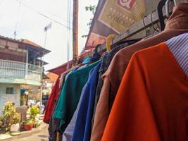 een dichtbij omhoog van sommige kleren drogen Aan een houten stok buiten een huis foto