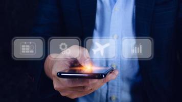 zakenman aanraken smartphone naar selecteer vlucht door drukken tintje scherm vliegtuig knoop, zaken vliegtuig vervoer concept foto