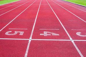 getallen beginnend punt Aan rood rennen volgen, rennen bijhouden en groen gras, direkt atletiek rennen bijhouden Bij sport stadion foto