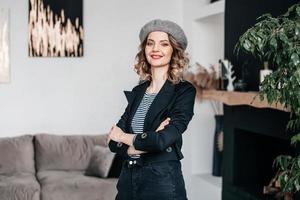 een meisje in een baret houdt haar haar- met haar handen en looks in de kader foto