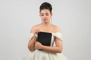 jong Aziatisch mooi bruid houding met tablet in hand- foto