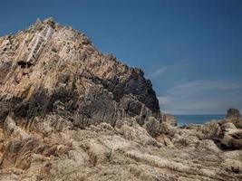 rotsen met rechte randen bij eb van een strand aan de Asturische kust foto