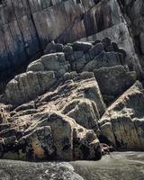 rotsen met rechte randen bij eb van een strand aan de Asturische kust