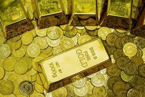 close-up van glanzende goudstaven op stapels gouden munten