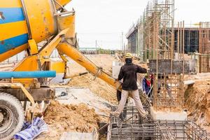 beton gieten tijdens commerciële betonnen vloeren van gebouwen in bouwplaats foto