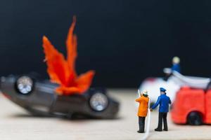 miniatuurbrandweerlieden bij een auto-ongeluk, auto-ongelukconcept