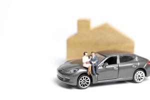 miniatuurmensen zittend op een auto op een witte achtergrond foto