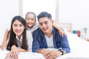 gelukkige familie liggend op een bed foto