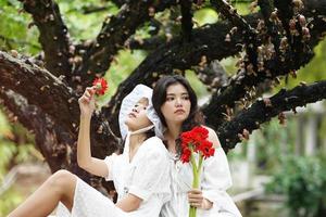 twee vrouwen onder een boom met bloemen foto