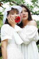 twee vrouwen met een rode gerbera foto