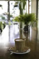 latte in een glas op een houten bureau foto