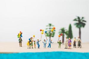 miniatuurmensen die van de zomervakantie genieten op het strand foto