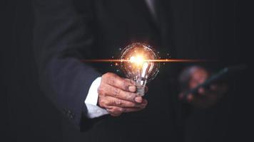 innovatie door ideeën en inspiratie ideeën. bedrijf hand- Holding licht lamp naar verlichten, idee van creativiteit en inspiratie concept van duurzame bedrijf ontwikkeling. foto