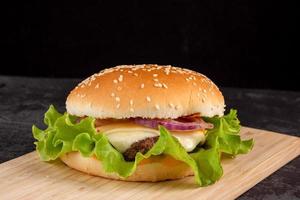 hamburger met rundvlees pasteitje Aan een houten bord foto