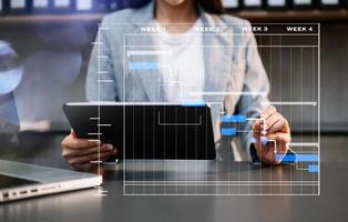 projectmanager werkt en werkt taken bij met mijlpalen voortgangsplanning en Gantt-diagramplanningsdiagram. zakelijke tram werkt op kantoor foto