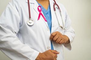 borst kanker, Aziatisch dokter vrouw met roze lint, symbool van wereld borst kanker dag. foto