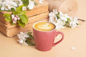 kop van koffie en bloesem appel twijgen met wijnoogst boeken. lente nog steeds leven samenstelling. foto