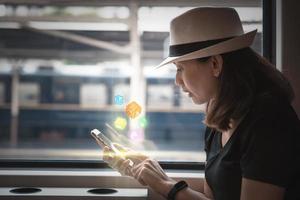 vrouw met behulp van smartphone op een trein foto