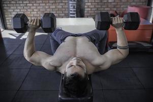 portret van aziatische man grote spier in de sportschool, mensen in thailand, training voor een goede gezondheid, lichaamsgewichttraining, fitness in de sportschool concept foto