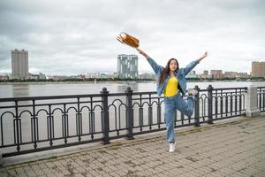 gelukkig meisje in een denim slijtage jumping met rugzak in haar hand- foto