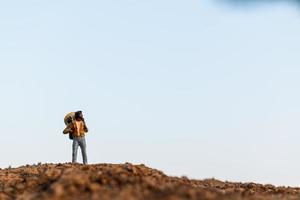 miniatuurreizigers met rugzakken bergbeklimmen, wandelen en backpacken buitenshuis concept foto