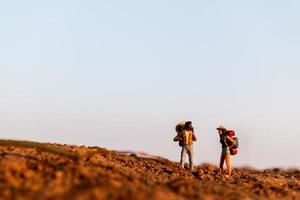 miniatuurreizigers met rugzakken bergbeklimmen, wandelen en backpacken buitenshuis concept foto