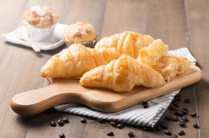 croissant brood Aan hout bord foto