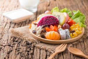 mengen fruit salade Aan hout bord met melk en hout achtergrond foto