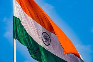 indiase vlag hoog op connaught plaats met trots in blauwe lucht, indiase vlag wapperen, indiase vlag op onafhankelijkheidsdag en republiek dag van india, tilt-up shot, wuivende indische vlag, har ghar tiranga foto