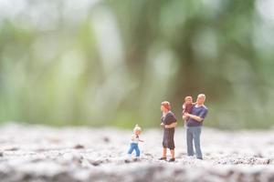 miniatuurouders met kinderen die buiten lopen, gelukkig familieconcept foto