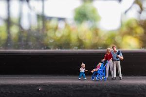 miniatuurouders met kinderen die buiten lopen, gelukkig familieconcept foto