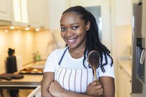 jong Afrikaanse vrouw is pratend selfie in de keuken foto