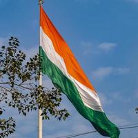 indiase vlag hoog op connaught plaats met trots in blauwe lucht, indiase vlag wapperen, indiase vlag op onafhankelijkheidsdag en republiek dag van india, tilt-up shot, wuivende indische vlag, har ghar tiranga foto