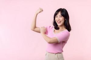 portret jong Aziatisch vrouw trots en zelfverzekerd tonen sterk spier sterkte armen gebogen poseren, voelt over haar succes prestatie. Dames machtiging, gelijkwaardigheid, gezond sterkte en moed concept foto